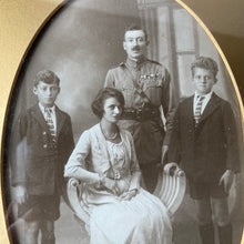 Load image into Gallery viewer, Oval framed vintage sepia family portrait.